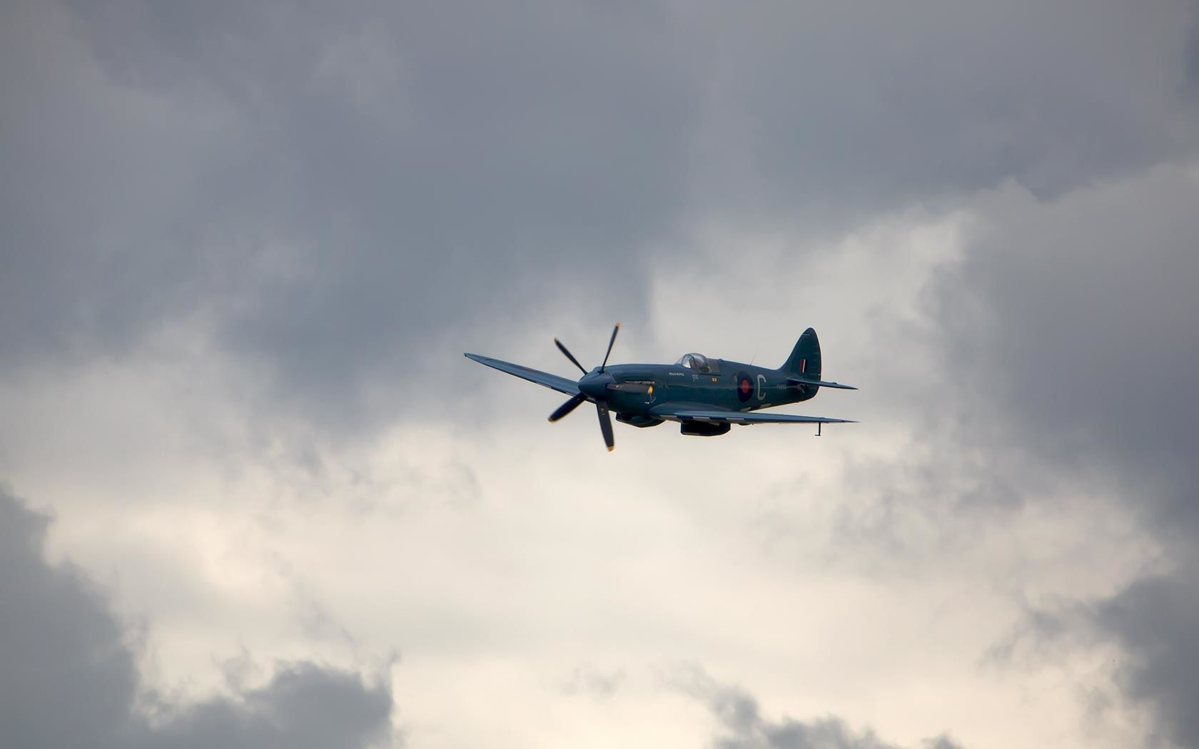 Aereo Spitfire in volo nuvoloso, 1680x1050 900p, Laptop