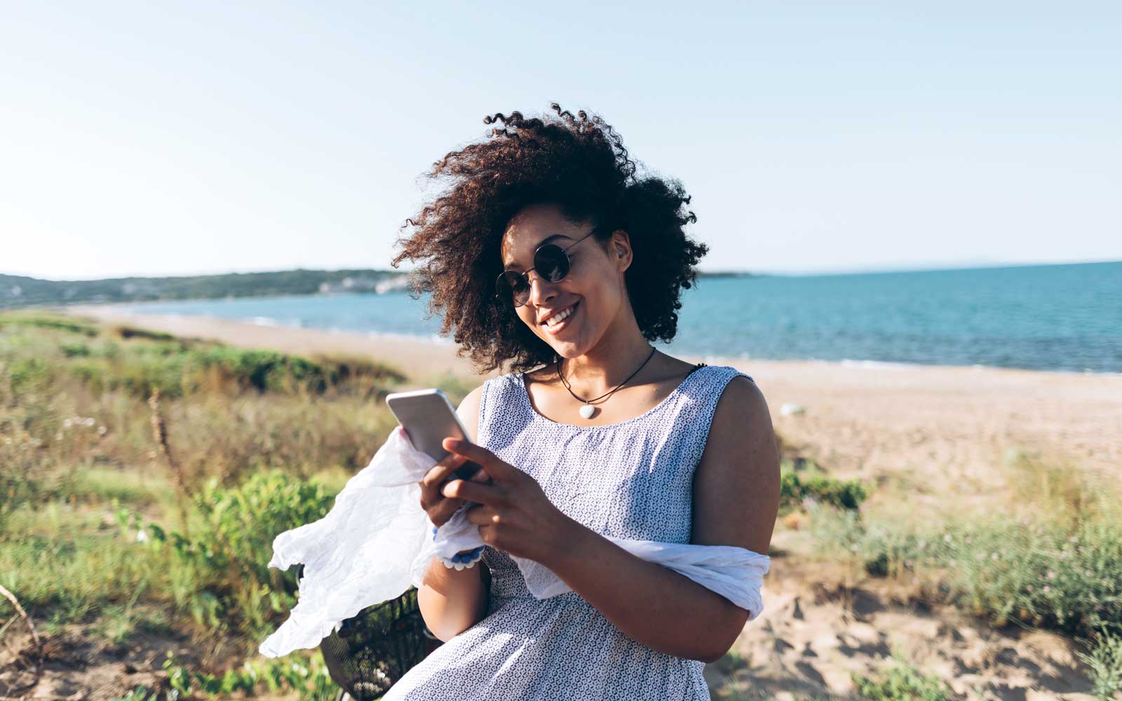 Donna sorridente al mare con smartphone, 1600x1000 HD, Laptop