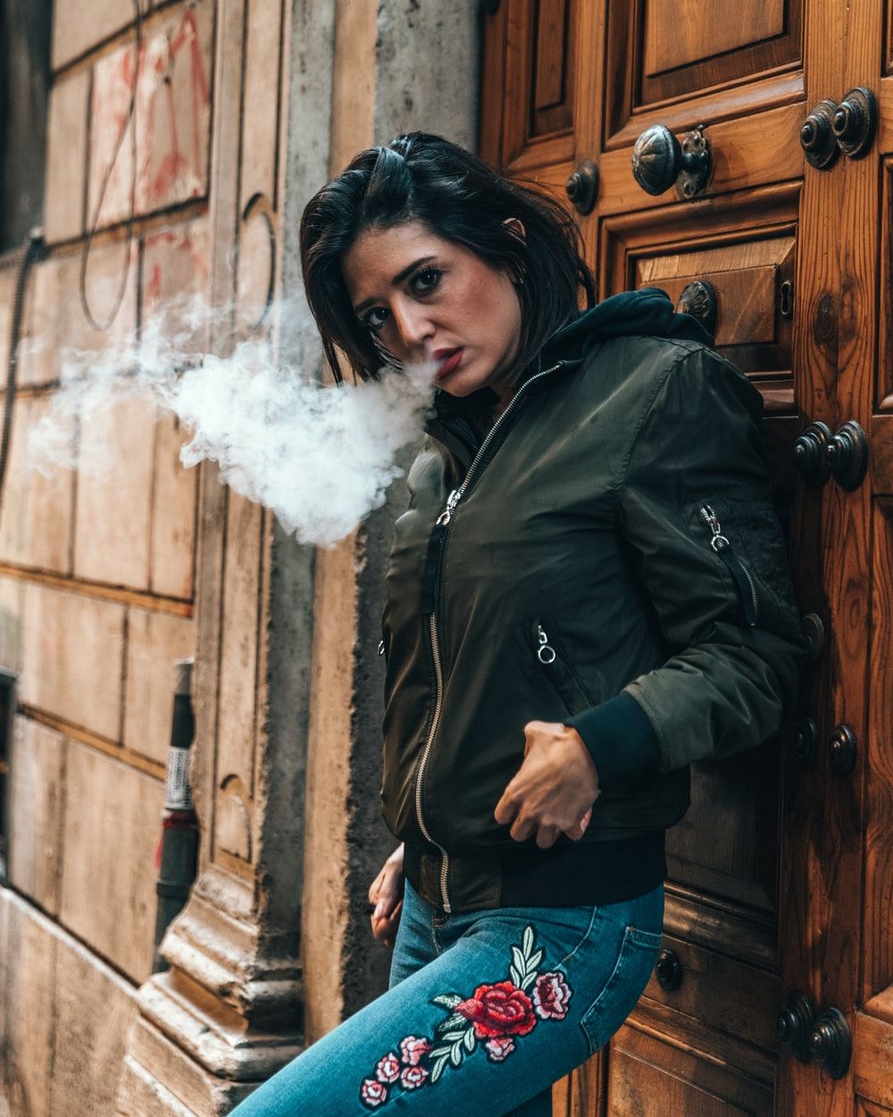 Ragazza fuma davanti portone, 1000x1250 Full HD Verticale, Smartphone