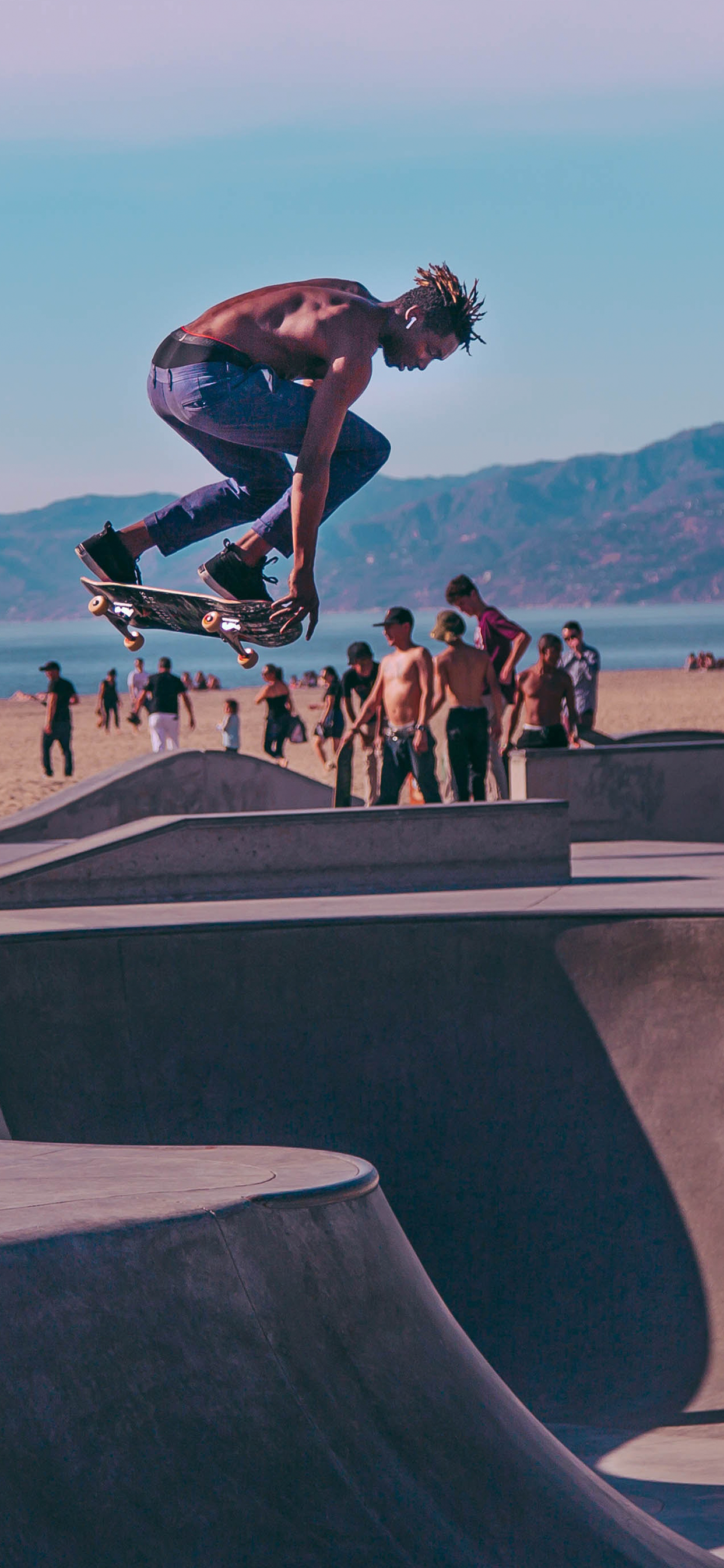 Skateboarder salta in skatepark, 1242x2688 Verticale, iPhone Pro